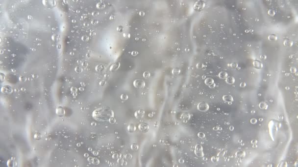 Movimiento, rotación del gel de crema líquida textura cosmética transparente con burbujas. Cosmética ecológica, medicina. Vista superior. Movimiento lento — Vídeo de stock