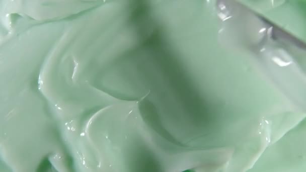 Creme verde, esfregaço, corretivo, base líquida cosmética, borrão de creme, escova de maquiagem. Movimento, rotação da amostra de produto de cuidados com a pele de beleza. Movimento lento — Vídeo de Stock