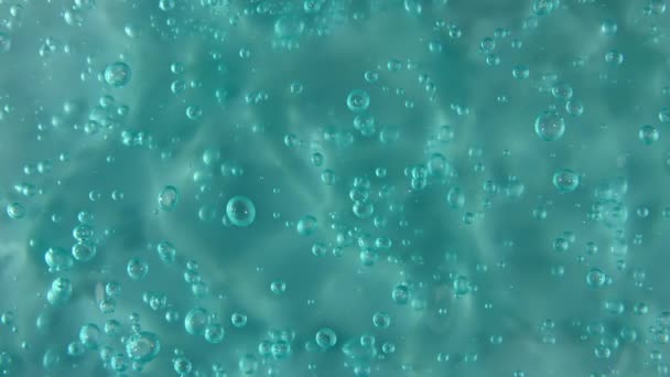 Movimiento, rotación del líquido gel fluido, textura crema cosmética azul con burbujas. Cosmética ecológica, medicina. Vista superior. Macro Shot — Vídeo de stock