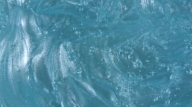 Hareket, sıvı jel sıvısının dönüşü, köpüklü mavi kozmetik krem dokusu. Organik kozmetik, ilaç. Üst Manzara. Makro Vuruş