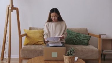 Orta Doğulu kadın uzaktan kumanda, iş arkadaşlarıyla görüntülü görüşme, belgeleri kontrol. Evde kal, uzaktan kumandayı karantinaya al. Yavaş çekim.