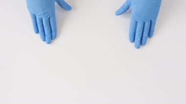 Doktorlar eldiven takıyor. Beyaz arka planda kalbin sembolünü gösteriyor..