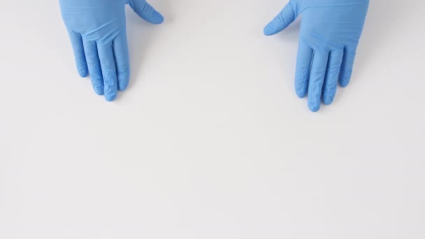 Doctors hands in medical gloves shows the symbol of the heart on white background with copy space. — Stock Video