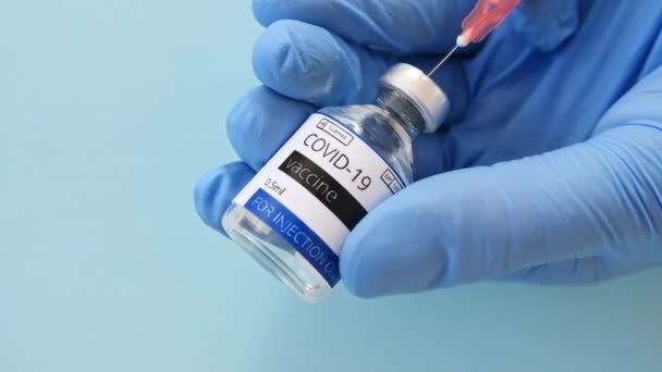 COVID-19 Vaccin i forskarhänder. Hand i blå handskar Fylla en spruta med vaccinmässling, Coronavirus, covid-19. Biontech, Moderna i ett Spruta. — Stockvideo