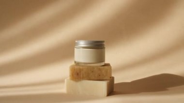 Güneş Işığındaki Sabun Çubuklarından Bej Podyumlarda Cam Kavanozda Krema. Gölge Avuç Yaprakları. Ürün Sunumu için Minimal Soyut Kozmetik Arkaplan. Ürün Sunumu.