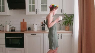 Genç bir kadın eğleniyor, dans ediyor, bir kepçeyle şarkı söylüyor, müzik videoları izliyor, modern bir mutfakta müzik dinliyor, evde yemek pişiriyor, kendi başının çaresine bakıyor..