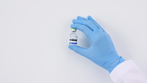 COVID-19 Impfstoff in Forscherhänden, Arzt stellt Spritze und Flasche mit Impfstoff für Coronavirus-Kur auf den Tisch. — Stockvideo