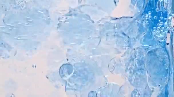 Macro-photo de diverses bulles d'air dans l'eau se levant sur fond blanc clair. Texture transparente d'échantillon cosmétique de gel de crème liquide avec des bulles. Concept de propreté et de pureté — Video