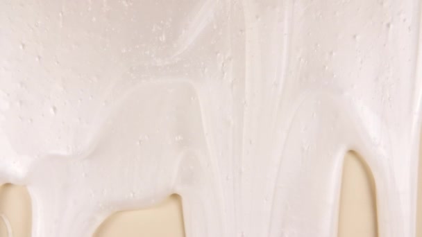 Beyaz Kozmetik Sıvı Kremi. Sade bej yüzeyinde molekül kabarcıkları akıyor. Makro Vuruş — Stok video