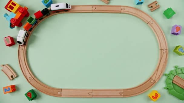 Детская деревянная железная дорога. Игрушечный поезд по кольцевой железной дороге. Детские образовательные игрушки. Вид сверху. Копировальное пространство. — стоковое видео