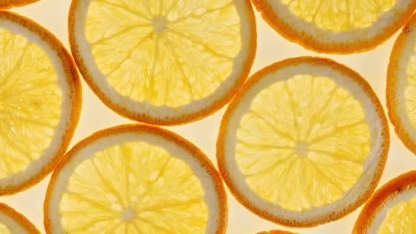 オレンジの背景に新鮮なオレンジスライスのスローモーション.オレンジフルーツパターン。健康食品の背景。マクロショット. — ストック動画