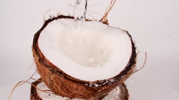 In Zeitlupe tropft Kokosmilch und -saft, Kokosnussöl plätschert über. Gesunde Ernährung. Makroschock. — Stockvideo
