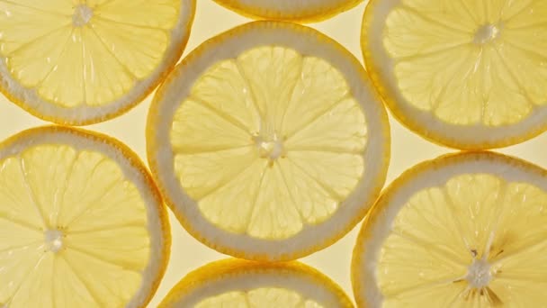 Macro Shot de fatias de frutas de limão fatiadas e girar. Lemons Fruit Pattern. Fundo Alimentar Saudável. Movimento lento. — Vídeo de Stock