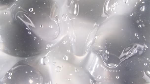 Macro Shot de burbujas de aire en crema de gel líquido cosmético transparente. Textura fluida con burbujas. Movimiento lento — Vídeos de Stock