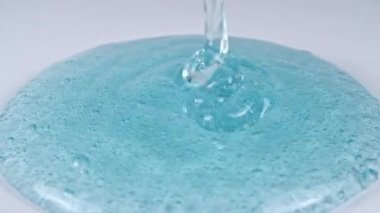 Molekül köpüklü Şeffaf Mavi Kozmetik Jel Kremi dökülüyor. Makro Vuruş