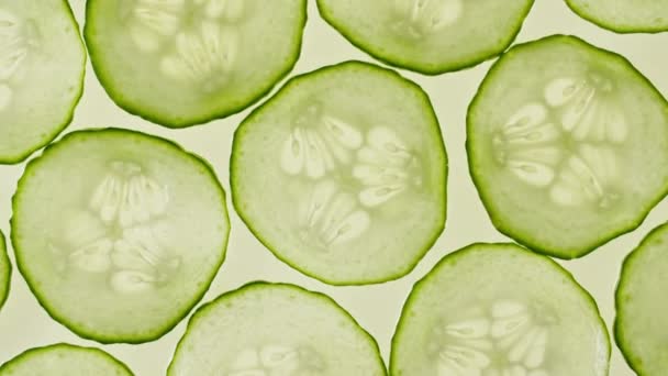 Macro Shot of Transparent Slice of Cucumber Fruit and Rotate. Primer plano Pepino fresco. Antecedentes alimentarios saludables. Moción lenta. — Vídeo de stock