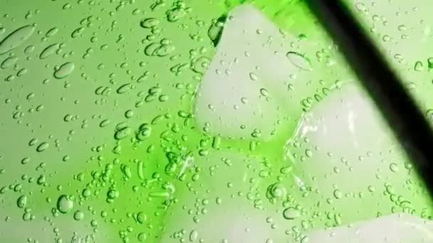 Makroaufnahme von Luftblasen in transparenter kosmetischer Flüssiggelcreme. Grüne Kosmetikflüssigkeit mit Blasen. Zeitlupe — Stockvideo