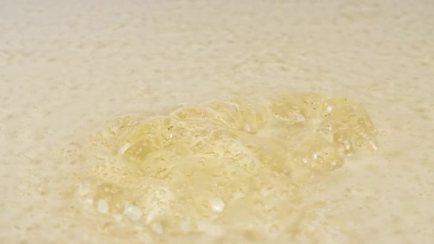 Slow Motion Shot of Pouring Oil Liquid Yellow Golden Hue. Cream Gel, Cosmetic Texture with Bubbles. Macro Shot. — Stock Video