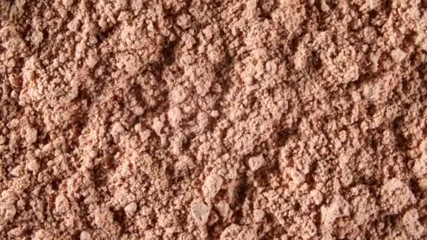 Droge Masker gemaakt van Clay Powder, Cosmetische Textuur met Rotatie. Brown Chocolade Proteïne Poeder. Productie van natuurlijke cosmetica. Macro Schot. Bovenaanzicht. 4K — Stockvideo