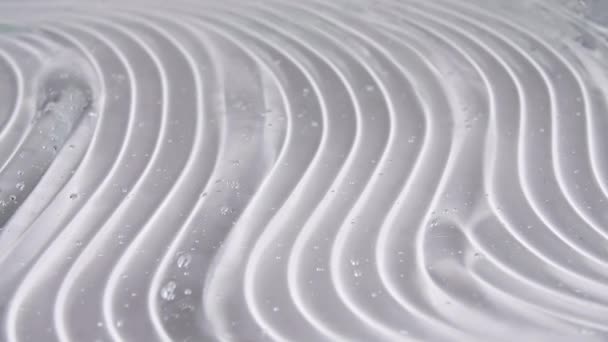 Макро-кадр воздушных пузырьков в прозрачном косметическом гелевом креме. Жидкая текстура с пузырьками. Медленное движение — стоковое видео