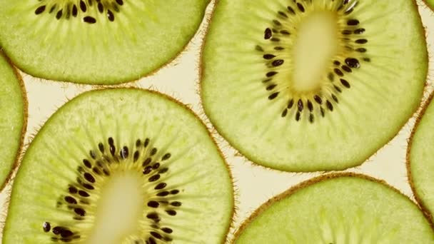 Makro záběr nakrájené plátky Kiwi ovoce a otočit. Kiwi Fruit Pattern. Zdravé potraviny pozadí. Pomalý pohyb. — Stock video