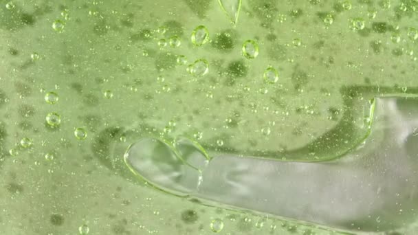 透明化粧品液体ジェルクリームの気泡のマクロショット。泡と緑の化粧品流体テクスチャ.スローモーション — ストック動画
