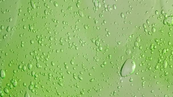 Макро-кадр воздушных пузырьков в прозрачном косметическом гелевом креме. Зеленая косметическая жидкость с пузырьками. Медленное движение — стоковое видео