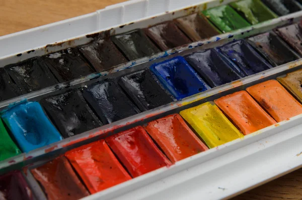 Akvarel napůl pan barvy palety na dřevěné pozadí — Stock fotografie