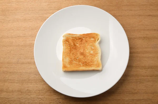 Φρυγανισμένο φέτα ψωμί στο άσπρο πιάτο — Φωτογραφία Αρχείου