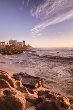 Kentsel Avustralya'da kayalık plaj güneş doğarken