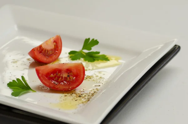 Tomate en rodajas y decorado con perejil y pimienta —  Fotos de Stock