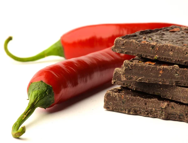 Chocolate negro y chiles picantes sobre fondo blanco — Foto de Stock