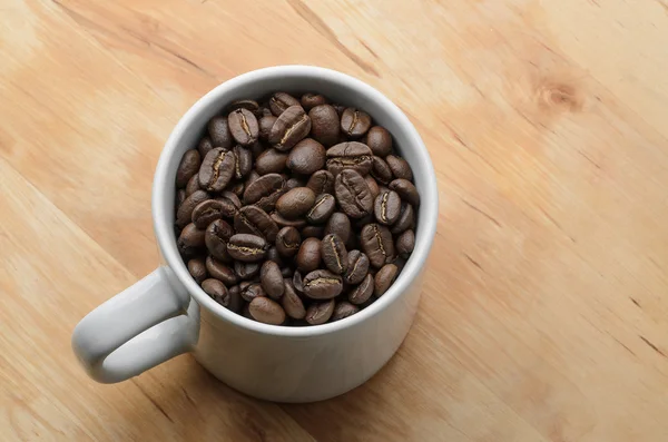 Biji kopi organik panggang dalam cangkir putih — Stok Foto