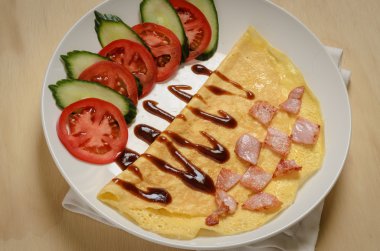 Pastırma sebze ve sos ile dekore edilmiş omlet katlanmış