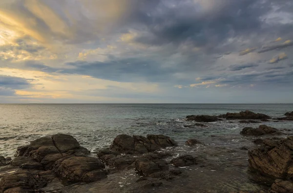 Dramática puesta de sol en el océano con rocas de roca —  Fotos de Stock