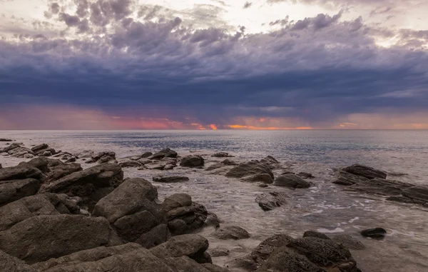 Pôr-do-sol dramático no oceano com rochas de pedra — Fotografia de Stock