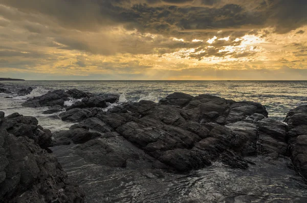 Dramática puesta de sol en el océano con rocas de roca —  Fotos de Stock
