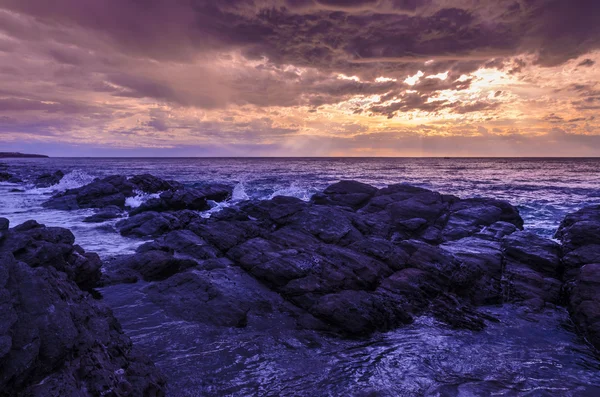Pôr-do-sol dramático no oceano com rochas de pedra — Fotografia de Stock