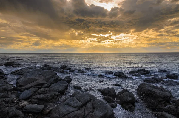 Pôr-do-sol dramático no oceano com rochas de pedra — Fotografia de Stock