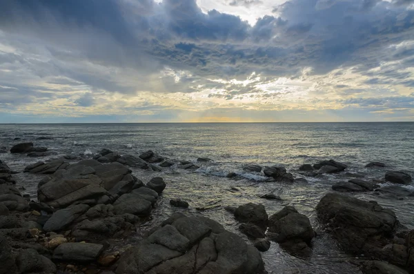 Dramatic sunset at the ocean with boulder rocks — Stock Photo, Image