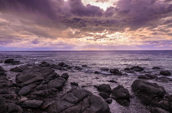 Dramática puesta de sol en el océano con rocas de roca —  Fotos de Stock