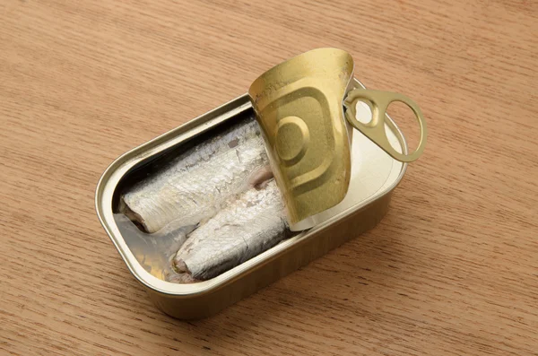 Étain sardines de poisson en conserve dans l'huile de fond en bois — Photo