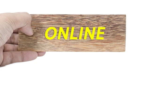 Mão segurando madeira marrom lisa com palavra online isolado fundo branco — Fotografia de Stock