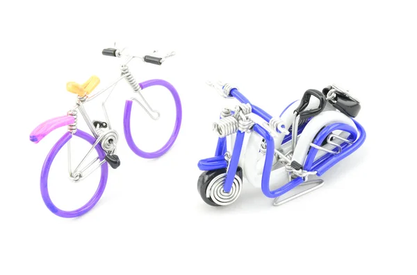 Wired purple miniature bicycle and blue scooter place opposite each other isolated white background — Stock Photo, Image