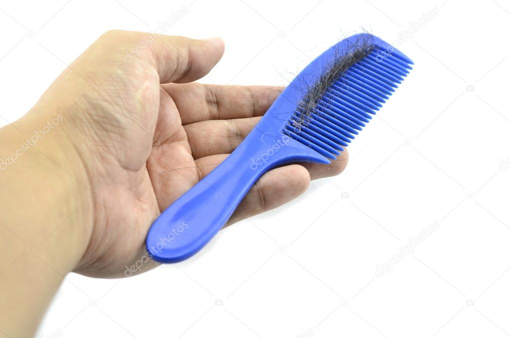 Hand holding blue comb contain hairfall