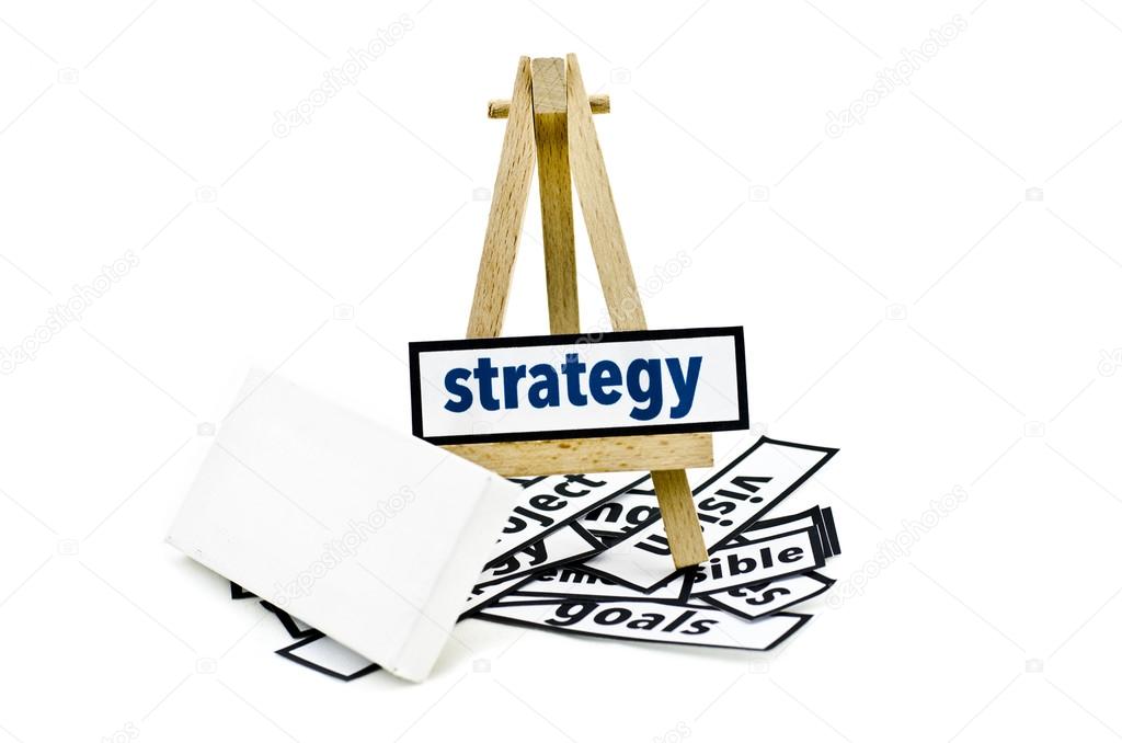 Concept strategy word on wooden stand.random cutted print paper and empty canvas frame isolated white background