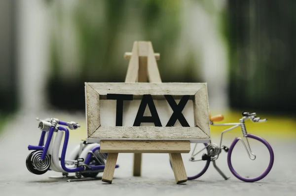 Soft bokeh and blurred image with word TAX. arial view of beautiful and creative scooter and bicyce handcrafted — Stock Photo, Image