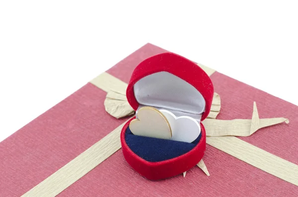 Herz-Symbol aus Holz in rotem Ringetui auf rotem Geschenkkarton mit Band aus Recyclingpapier isoliert weißer Hintergrund — Stockfoto