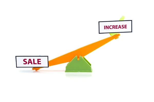 Image concept de déséquilibre mot vente en bas et augmenter en haut.vert et orange couleur jouet balançoire — Photo