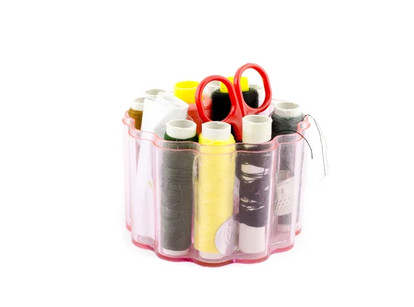 Sewing set with colorful thread, red scissor in round transparent storage box — Stock Photo, Image